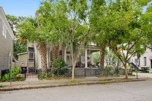 una casa con alberi di fronte a una recinzione di Starland Yellow Door Retreat a Savannah