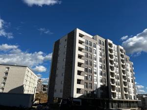 un grand immeuble d'appartements blanc dans une ville dans l'établissement Blini Exclusive, à Pristina