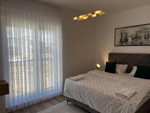 a bedroom with a bed and a large window at Blini Exclusive in Prishtinë