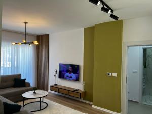 a living room with a couch and a tv on a wall at Blini Exclusive in Prishtinë