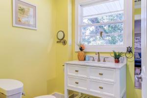 a bathroom with a white sink and a window at Surf Bungalow in Folly Beach +33 photos