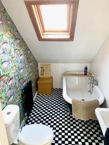 a bathroom with a toilet and a tub and a sink at Bats by the Sea at Number 23 in Scarborough