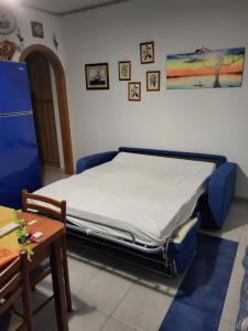 a bedroom with a bed with blue chairs and a table at Casa Linda Taormina Etna in Fondachello