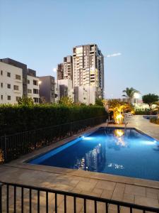 a swimming pool in a city with tall buildings at Luxury Stay in Sheikh Zayed