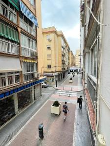 Due persone che camminano per strada in una città di Apartamento Deborah a Málaga
