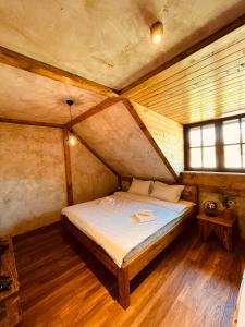 a small bedroom with a bed in a attic at ETNO SELO VRANEŠA Zlatar in Nova Varoš +37 photos