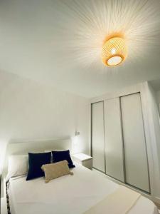 1 dormitorio con cama blanca grande y luz en Acogedor y cómodo apartamento con piscina, en Las Palmas de Gran Canaria