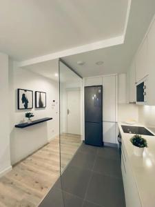 een grote witte keuken met een blauwe deur erin bij Acogedor y cómodo apartamento con piscina in Las Palmas de Gran Canaria