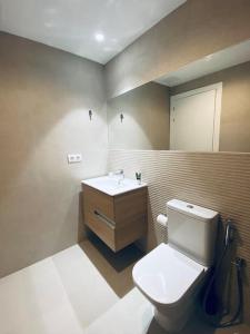 a bathroom with a white toilet and a sink at Acogedor y cómodo apartamento con piscina in Las Palmas de Gran Canaria