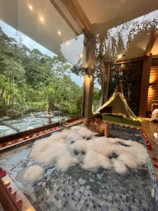 un hombre en una bañera con nubes en el agua en Saguamby Mindo Lodge, en Mindo