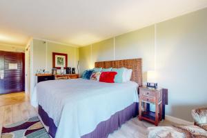 a bedroom with a large bed with red pillows at Kauai Beach Resort #3124 in Lihue