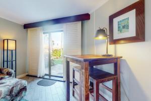 a room with a table and a lamp and a door at Kauai Beach Resort #3124 in Lihue