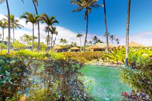 um resort com palmeiras e uma piscina de água em Kauai Beach Resort #3124 em Lihue