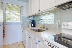 a kitchen with white cabinets and a sink at Kapa'a Sands 09 in Kapaa