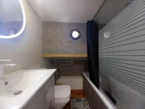 a bathroom with a tub and a toilet and a sink at Appartement atypique indépendant sur péniche in Metz
