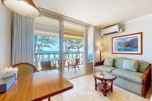 a living room with a couch and a table at Islander on the Beach 353 in Kapaa