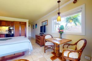a bedroom with a bed and a table and chairs at Islander on the Beach 339 in Kapaa