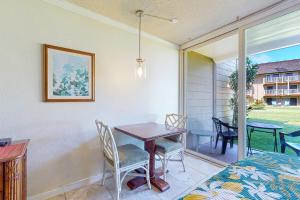 a room with a table and chairs and a window at Islander on the Beach 121 in Kapaa