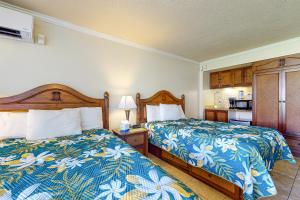 a hotel room with two beds and a kitchen at Islander on the Beach 121 in Kapaa