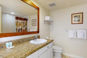 a bathroom with a sink and a toilet and a mirror at Islander on the Beach 121 in Kapaa +19 photos