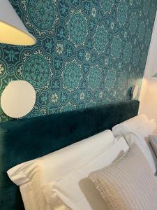 una camera da letto con una parete decorata con carta da parati verde e bianca di Tecnopolo Fiera Suite a Bologna