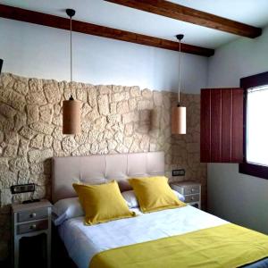 1 dormitorio con 1 cama con 2 almohadas amarillas en Casa rural Solanilla, en Solanilla