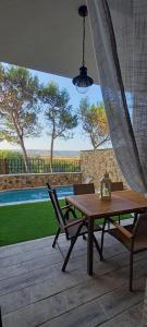 une table et des chaises en bois sur une terrasse avec une piscine dans l'établissement Casa rural Solanilla, à Solanilla