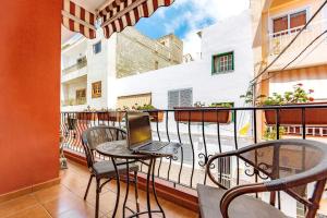 a balcony with a table with a laptop on it at Playa San Juan apartment in Playa de San Juan