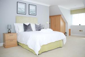 una camera da letto con un grande letto bianco e una finestra di Luxury, Spacious Home with Private Driveway Beaches and Gower in close proximity a Parkmill