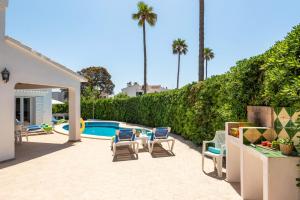 um pátio com cadeiras e uma piscina em Villa Mencia by Villa Plus em S'Algar
