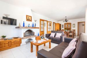 ein Wohnzimmer mit einem Sofa und einem Kamin in der Unterkunft Villa Mencia by Villa Plus in S'Algar