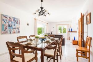 a dining room and living room with a table and chairs at Villa Mencia by Villa Plus in S'Algar