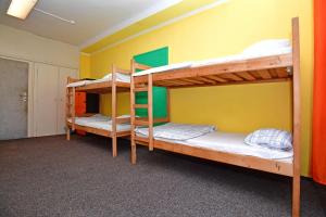 2 Etagenbetten in einem Zimmer mit gelber Wand in der Unterkunft Prague Old Town Hostel in Prag