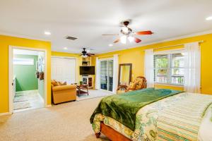 sypialnia z żółtymi ścianami, łóżkiem i wentylatorem sufitowym w obiekcie Marigold Cottage w mieście Tybee Island