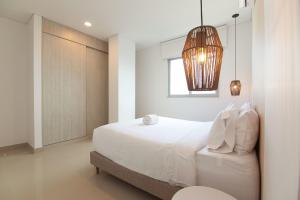 1 dormitorio con cama blanca y ventana en Wynwood Las Flores in Cartagena, en Cartagena de Indias
