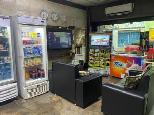 Ein Laden mit zwei Kühlschränken, Stühlen und einem Fernseher in der Unterkunft Hotel Central Gold-Econômico in Manaus