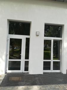 two glass doors on a white building with at Mirabella 1 in Kołobrzeg