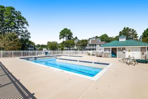 a swimming pool with a fence and a building at Sea Colony --- 56065 Pinewood Drive in Bethany Beach