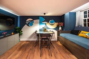 a bedroom with blue walls and a table and a bed at The Nest - Luxury 16 person Apt w jacuzzi & parking in Blackpool