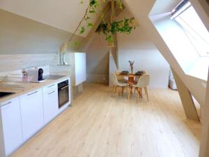 a kitchen with a table and a dining room at Le Green Cosy in Évreux