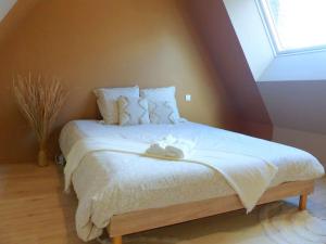 a bedroom with a bed with white sheets and a window at Le Green Cosy in Évreux