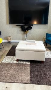 reposapiés blanco en una sala de estar con TV en Cheerful 3 bedroom Townhouse with free parking., en Billericay
