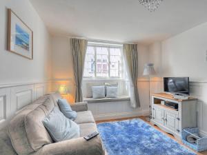 a living room with a couch and a television at Watersplash Cottage in Lyme Regis
