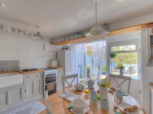 a kitchen with a dining table and a kitchen with a window at Watersplash Cottage in Lyme Regis