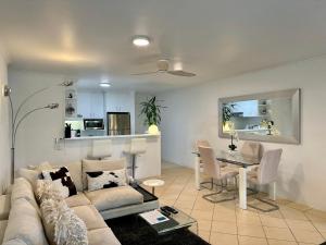 Noosa Luxury Apartment في نوسا هيدز: غرفة معيشة بها أريكة وطاولة +17 صورة