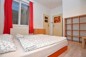 a bedroom with a large bed with red curtains at Prague Old Town Hostel in Prague