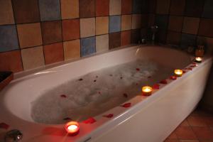 a bath tub filled with candles and red hearts at Holiday home Ca' del Cinema in Mombercelli +35 photos
