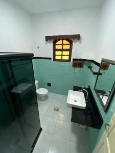 baño con aseo y lavabo y ventana en Casa em Arraial do Cabo, en Arraial do Cabo