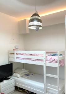 a bedroom with two bunk beds and a television at Architect designed house with pool and private beach in Eretria +30 photos