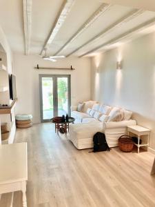 a living room with a white couch and a table at Architect designed house with pool and private beach in Eretria